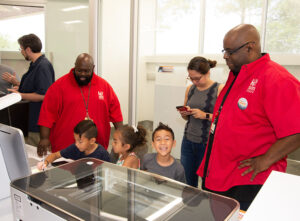 Group of children and volunteers in the maker lab.