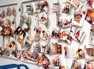 Group of photos of library patrons and volunteers hung on a board.