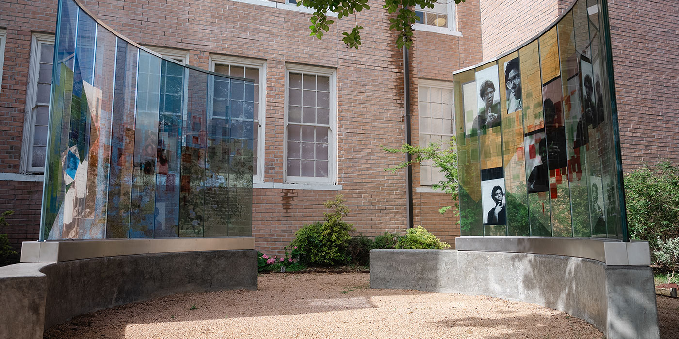 Outdoor art installation with benches and floating imagery.