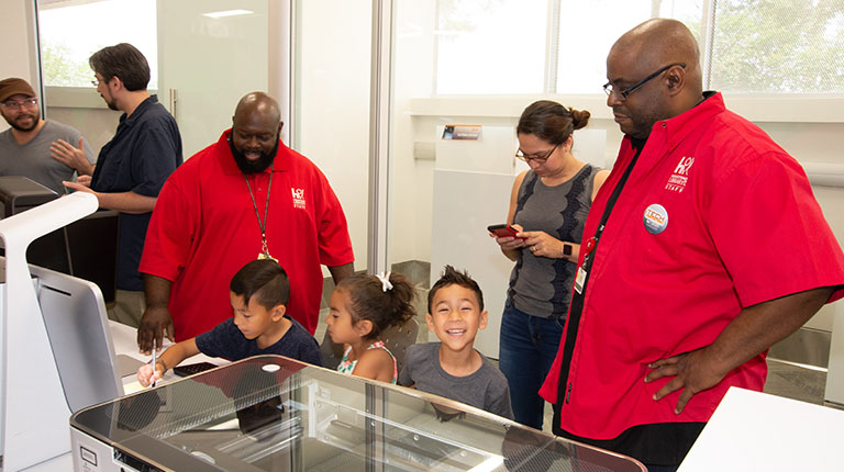Group of adults and kids working in the Maker Lab.