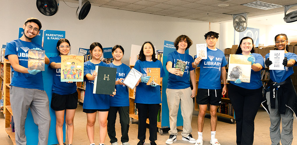 Group of volunteers lined up and holding books.