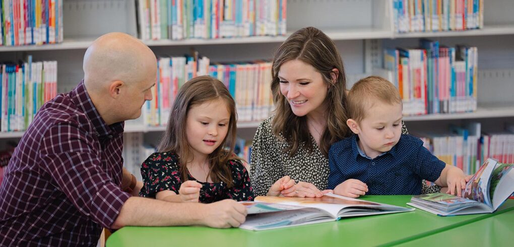 A family reading a couple of books together.
