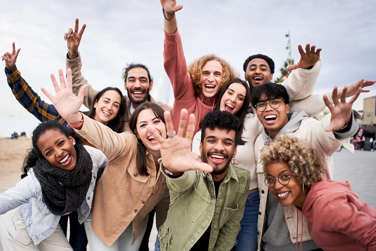 A group of young professionals celebrating with their hands in the air.